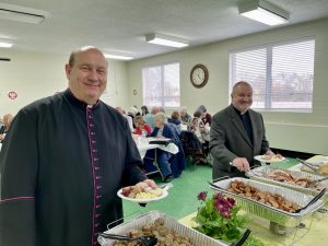 Rev. Canon Walter J. Ptak and Rev. Gary Michalik at the buffet table in the Ss. Peter & Paul Activities Building at the Society’s Twelfth Annual Spring Pilgrimage & Święconka on Saturday, April 22, 2023, in celebration of the parish’s 100th anniversary (Alina Klin, Ph.D.)