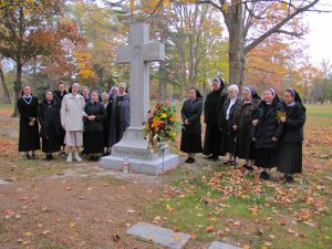 A large group of Felician Sisters, including Sisters from Vietnam, Haiti, and Poland (via Rome, Italy), gather at the Felician Sisters’ monument in Holy Sepulchre Cemetery, marking the spot where 495 Felician nuns have been buried since 1924